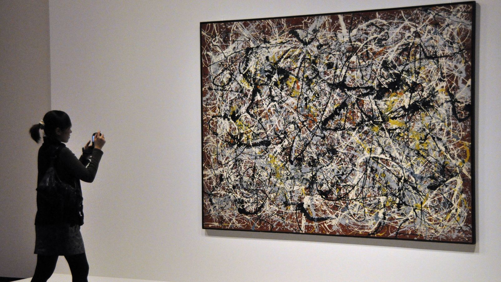 Foto: Una mujer fotografía uno de los cuadros de Jackson Pollock, en una retrospectiva en Tokio hace tres años. (EFE)