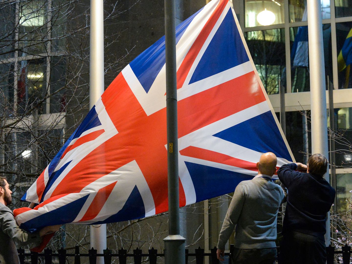 Trabajadores del Parlamento Europeo en Bruselas arrían la bandera británica. (Reuters)