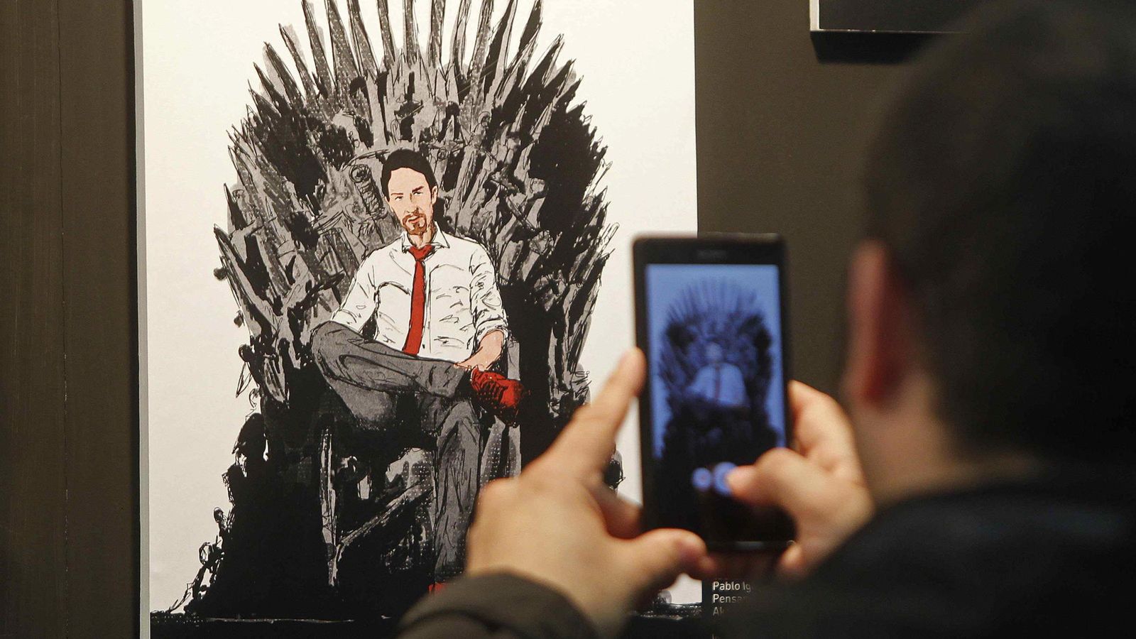 Foto: Un visitante realiza una fotografía a la portada de 'Ganar o morir. Lecciones políticas en juego de tronos', coordinado por Pablo Iglesias. (EFE)