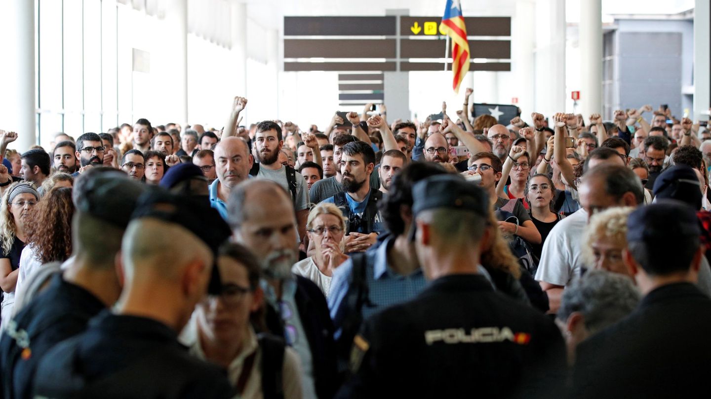 Agentes de los Mossos d'Esquadra y de la Policía Nacional controlan el acceso a la T1 del Aeropuerto de El Prat. (EFE)