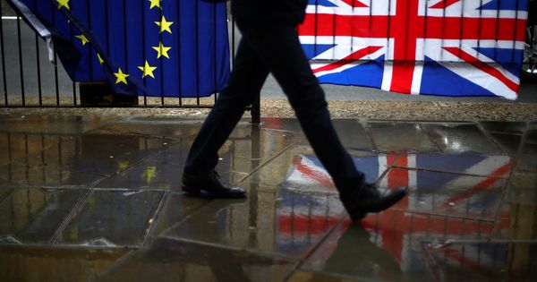 Foto: Una persona camina ante las banderas europeas y británicas en Londres. (Reuters)