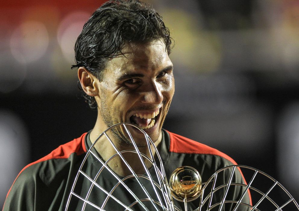Foto: Nadal muerde el trofeo de campeón en Río (Efe). 