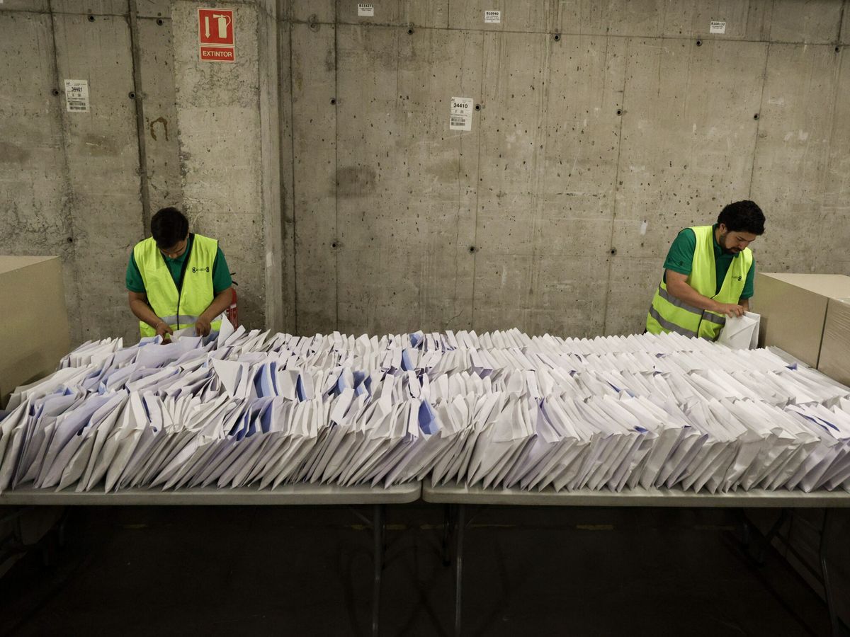 Foto: Varios operarios trabajan en la preparación de papeletas, urnas y demás elementos para el 28-M. (EFE/Quique García)