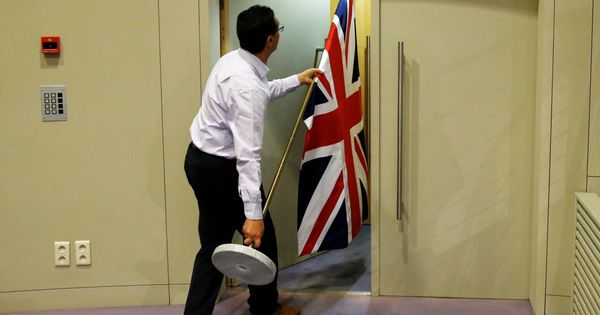 Foto: Un trabajador coloca una bandera británica antes de una rueda de prensa de David Davis y Michel Barnier en Bruselas. (Reuters) 