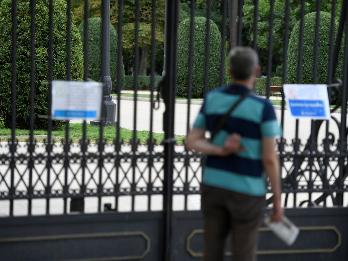 Foto: Un hombre lee los carteles que informan del cierre del parque del Retiro en Madrid. (EFE)