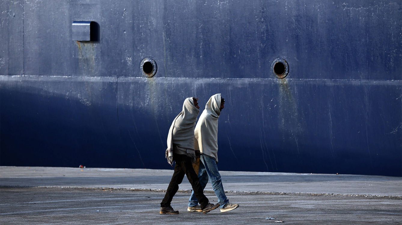 Foto: Dos migrantes caminan junto a un ferry en la isla de Lesbos. (Getty/Carl Court)