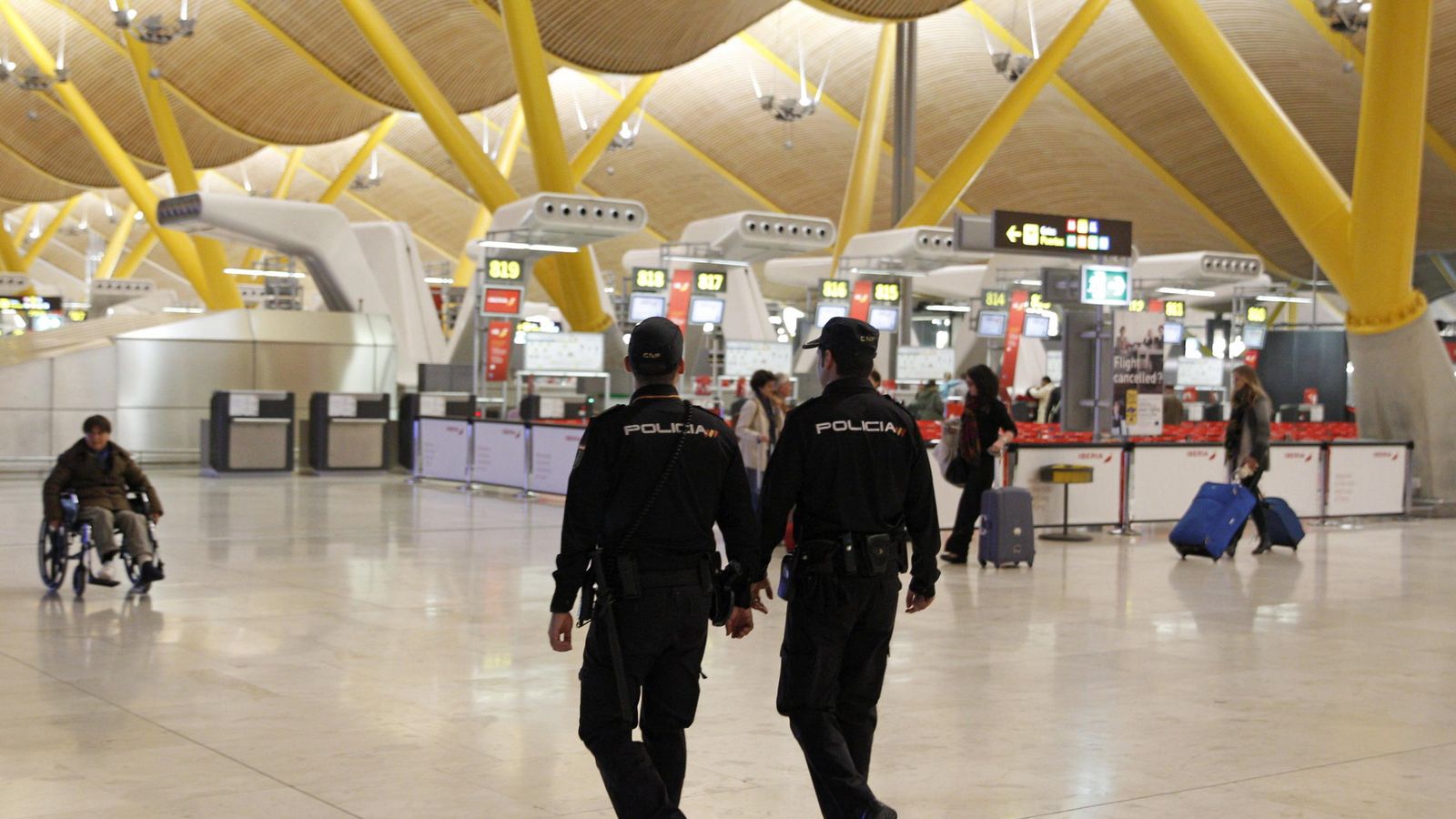 Foto: Efectivos policiales patrullan la T-4 del aeropuerto de Madrid Barajas. (EFE)