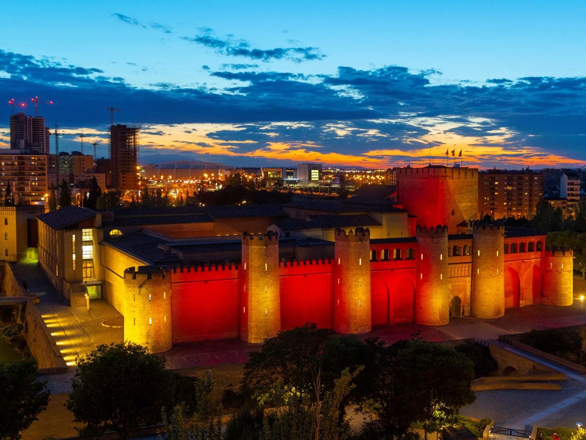 Foto: La Aljafería, en Zaragoza, iluminado con los colores de la bandera de Aragón por el día de San Jorge. (EFE/Javier Belver)
