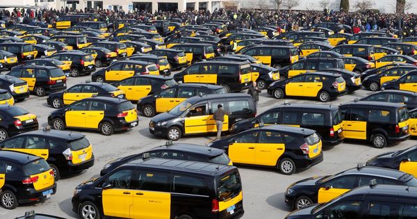 Foto: Centenares de taxistas durante la asamblea que han celebrado en el aparcamiento de la T2 del Aeropuerto de El Prat. (EFE)