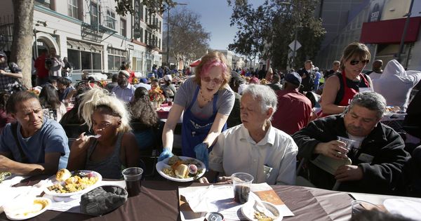 Foto: Una voluntaria entrega un plato durante una comida de Acción de Gracias para personas sin hogar y menos afortunadas. (EFE)
