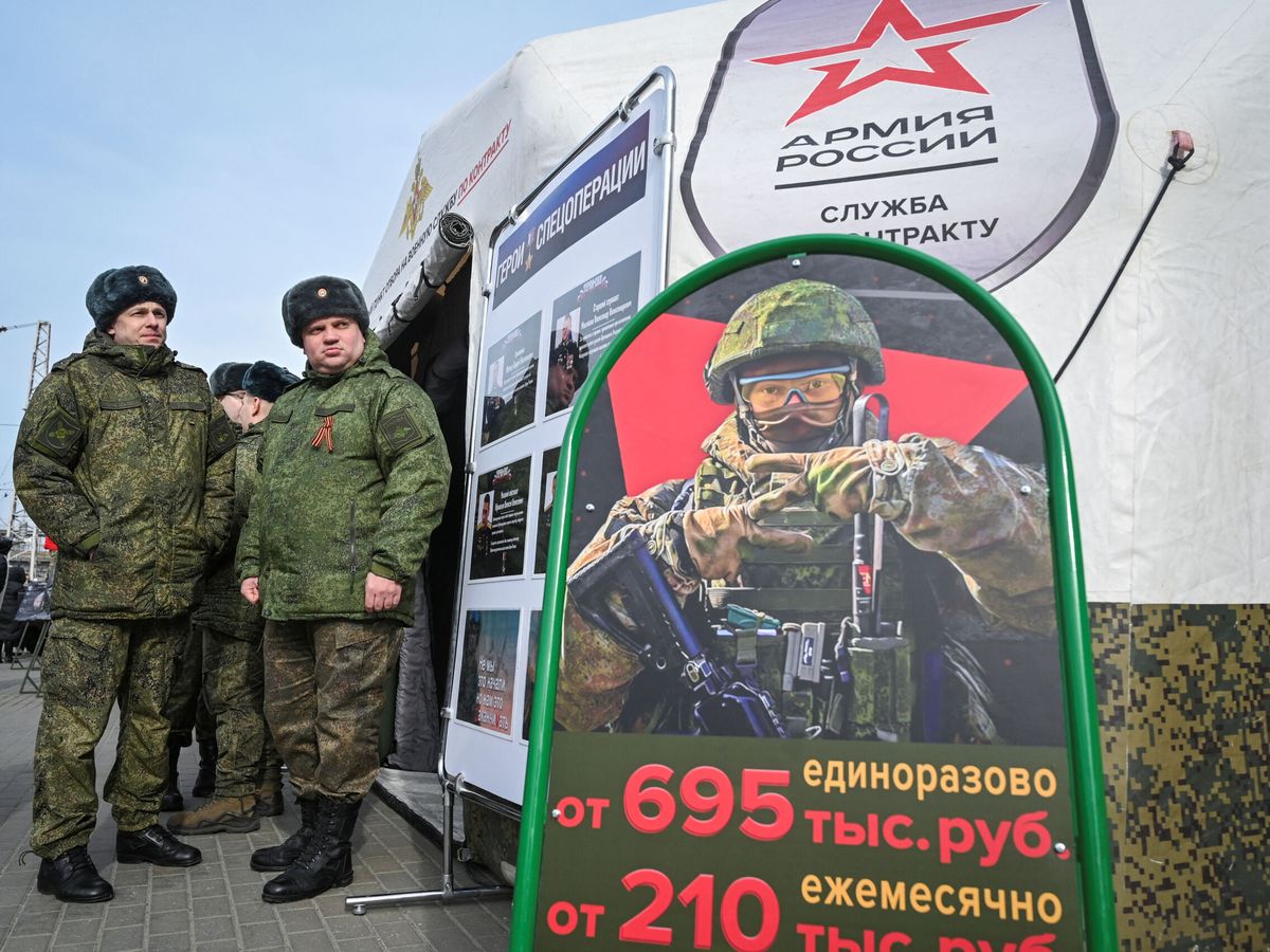 Foto: Militares del ejército ruso se encuentran cerca de un centro de reclutamiento móvil con un tablero que contiene información sobre pagos. (Reuters / Sergey Pivovarov)