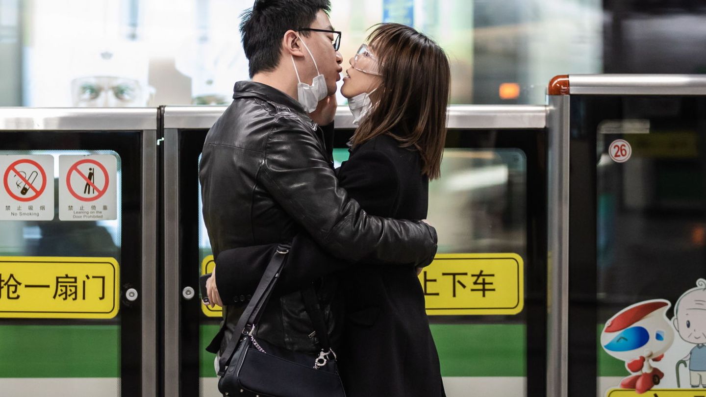 La imagen viral de una pareja que se quita las mascarillas para besarse en China. (EFE)
