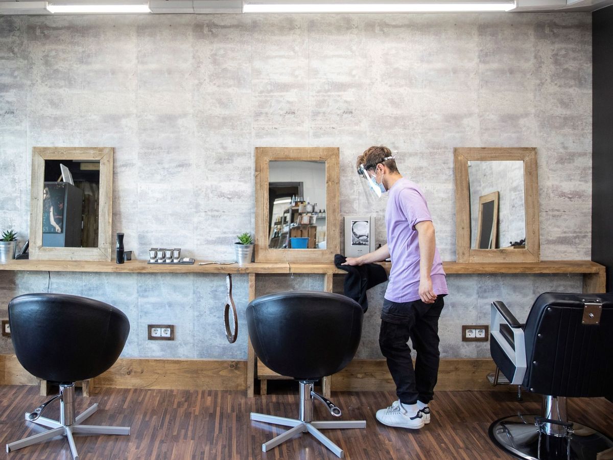 Foto: Un empleado desinfecta la zona de corte de una peluquería de Madrid, este 2 de mayo. (EFE)