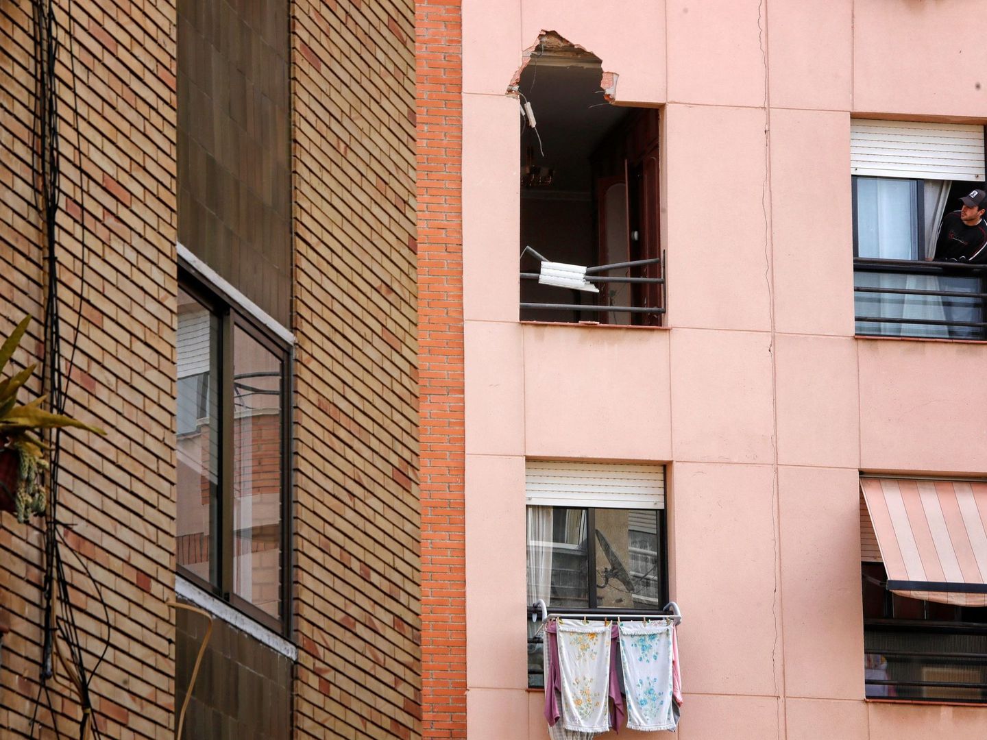 Un joven observa la ventana por donde entró el trozo de metal procedente de la explosión. (EFE)