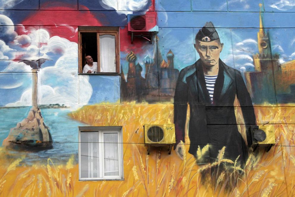 Un hombre observa desde su ventana un mural pintado recientemente en Sebastopol (Reuters).