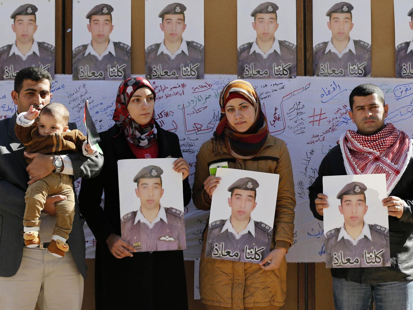 Familiares de Kasaesbeh sostienen fotos del piloto durante una manifestación en Amán (Reuters).