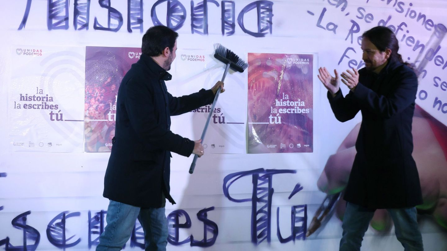 Pablo Iglesias y Alberto Garzón, durante la tradicional pegada de carteles. (EFE)