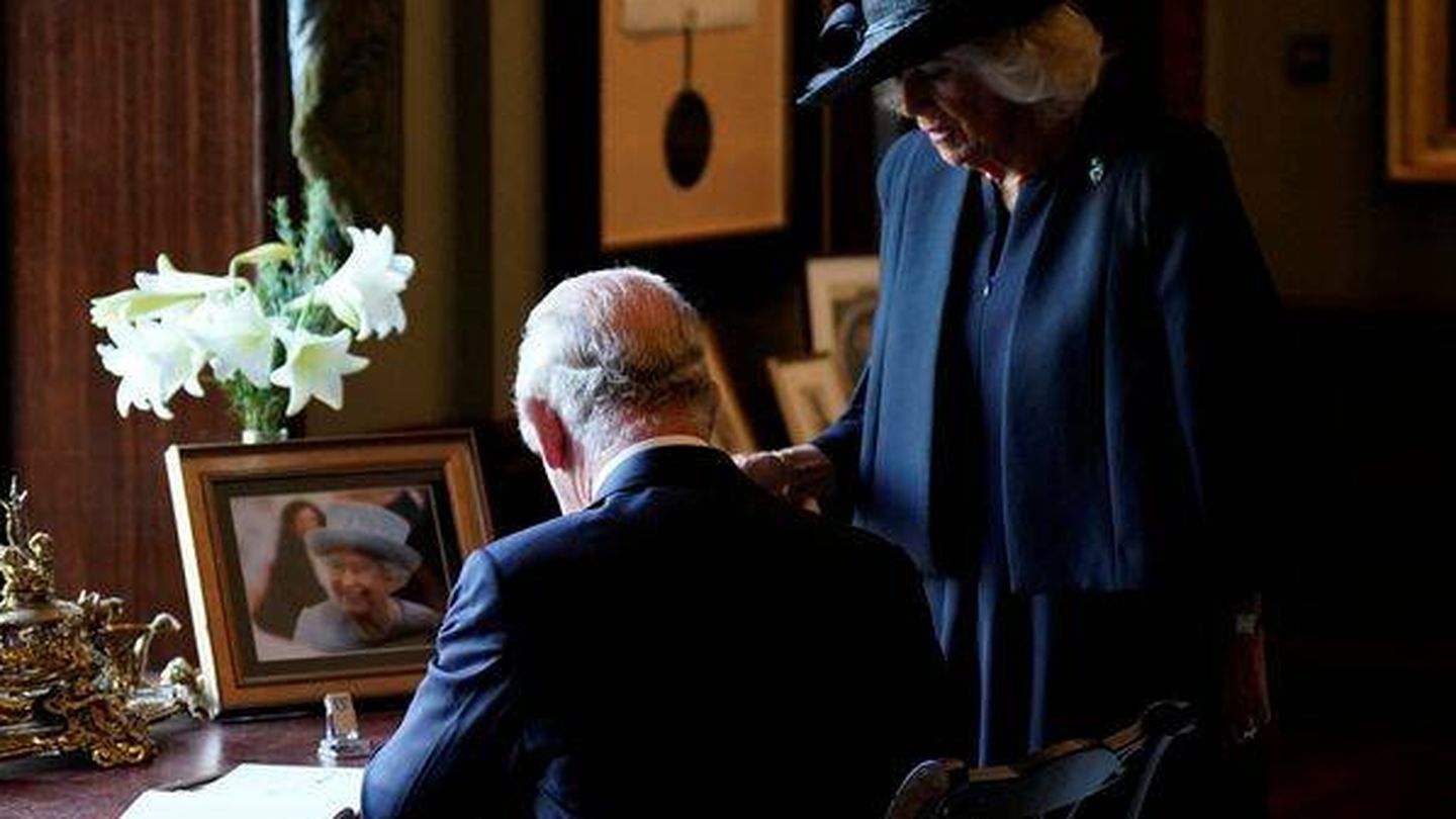 El rey Carlos y la reina consorte firman en el libro de visitas del castillo de Hillsborough. (Reuters/Niall Carson)