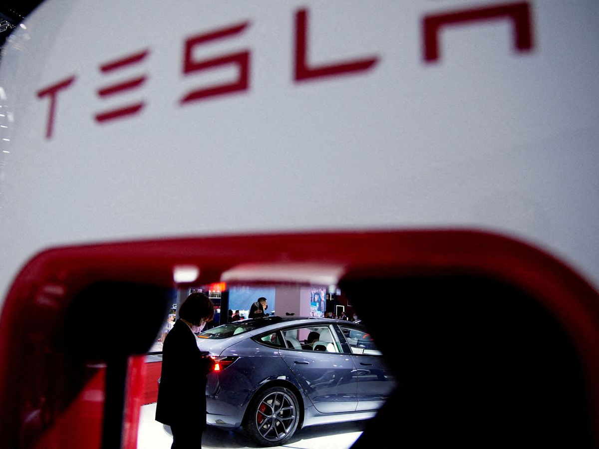 Foto: Un Tesla visto a través de una estación de carga en una exposición en Shanghái (China). (Reuters)