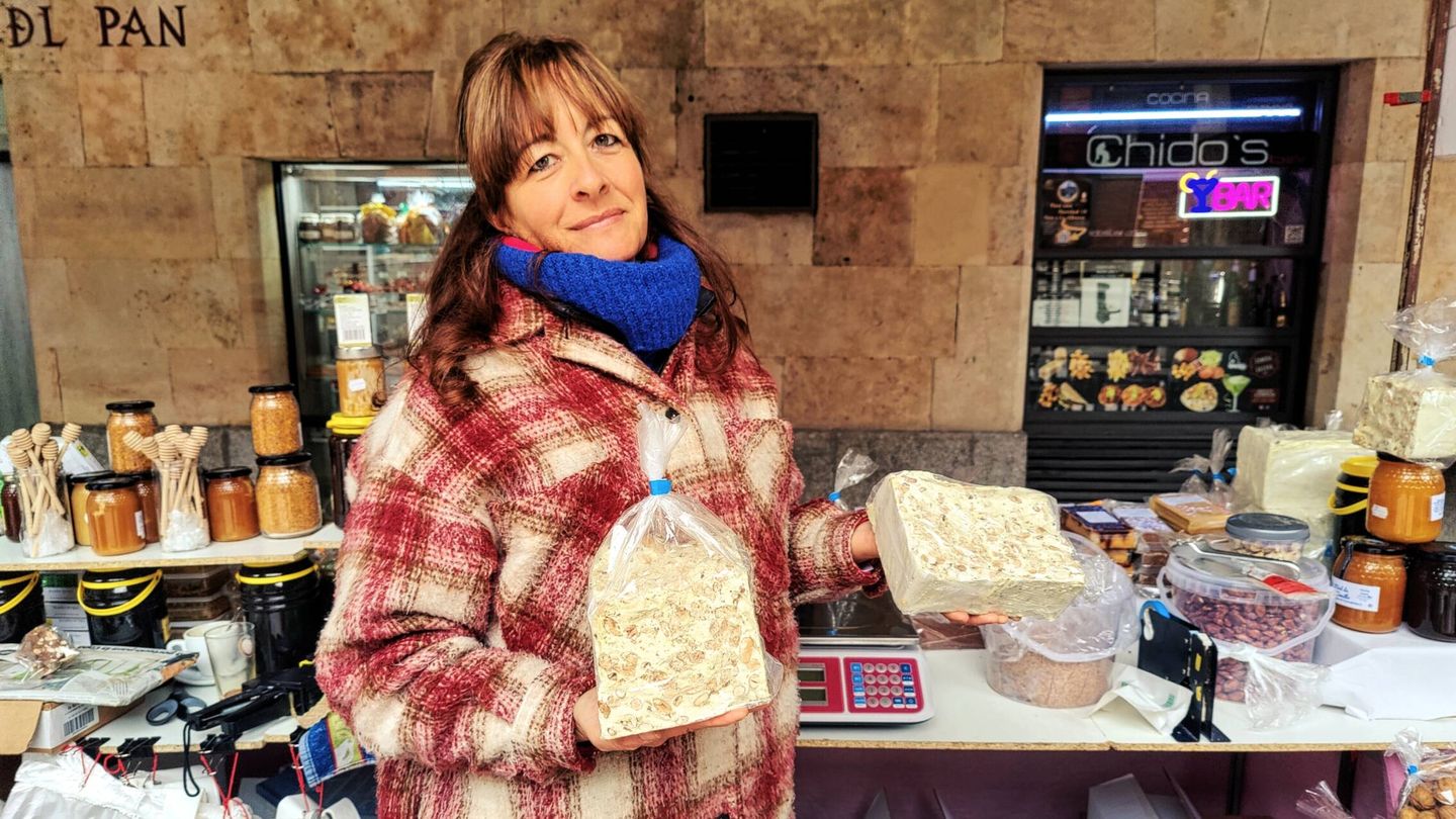 Emilia sostiene los turrones que más éxito tienen entre los clientes de su puesto en la plaza Mayor de Salamanca. (M. B.)