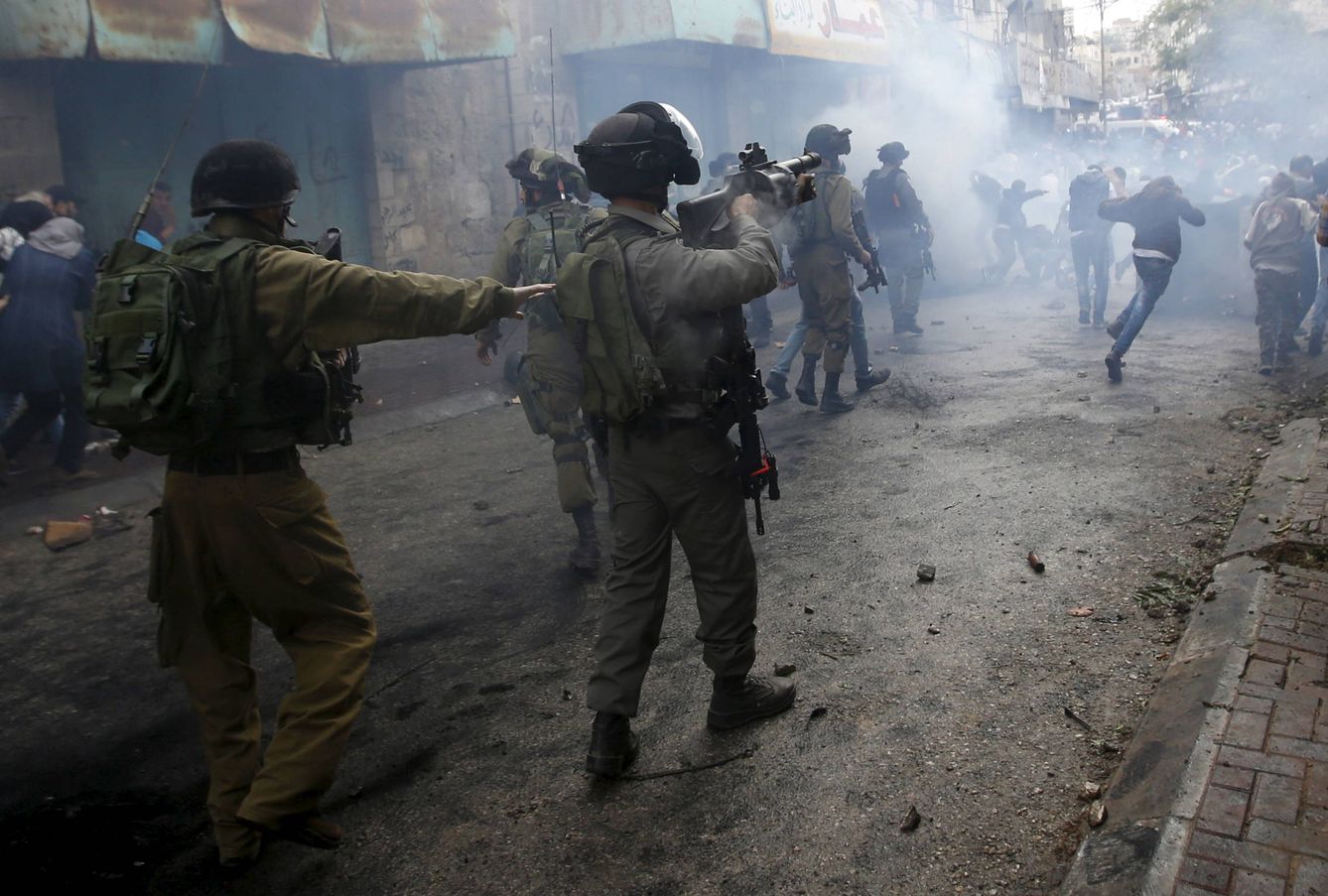 Palestinos huyen de las tropas israelíes durante choques en Hebrón, Cisjordania. (Reuters) 