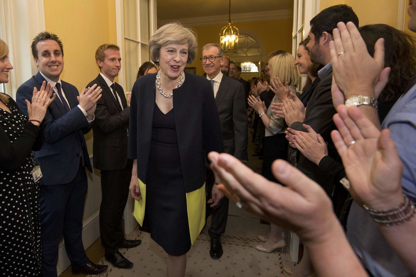 Miembros del equipo de Theresa May aplauden su entrada en el nº 10 de Downing Street. (Reuters)