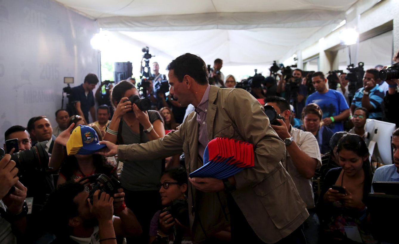 Foto: El líder opositor Henrique Capriles regala gorras a periodistas a su llegada a una rueda de prensa en Caracas, el 7 de diciembre de 2015 (Reuters). 