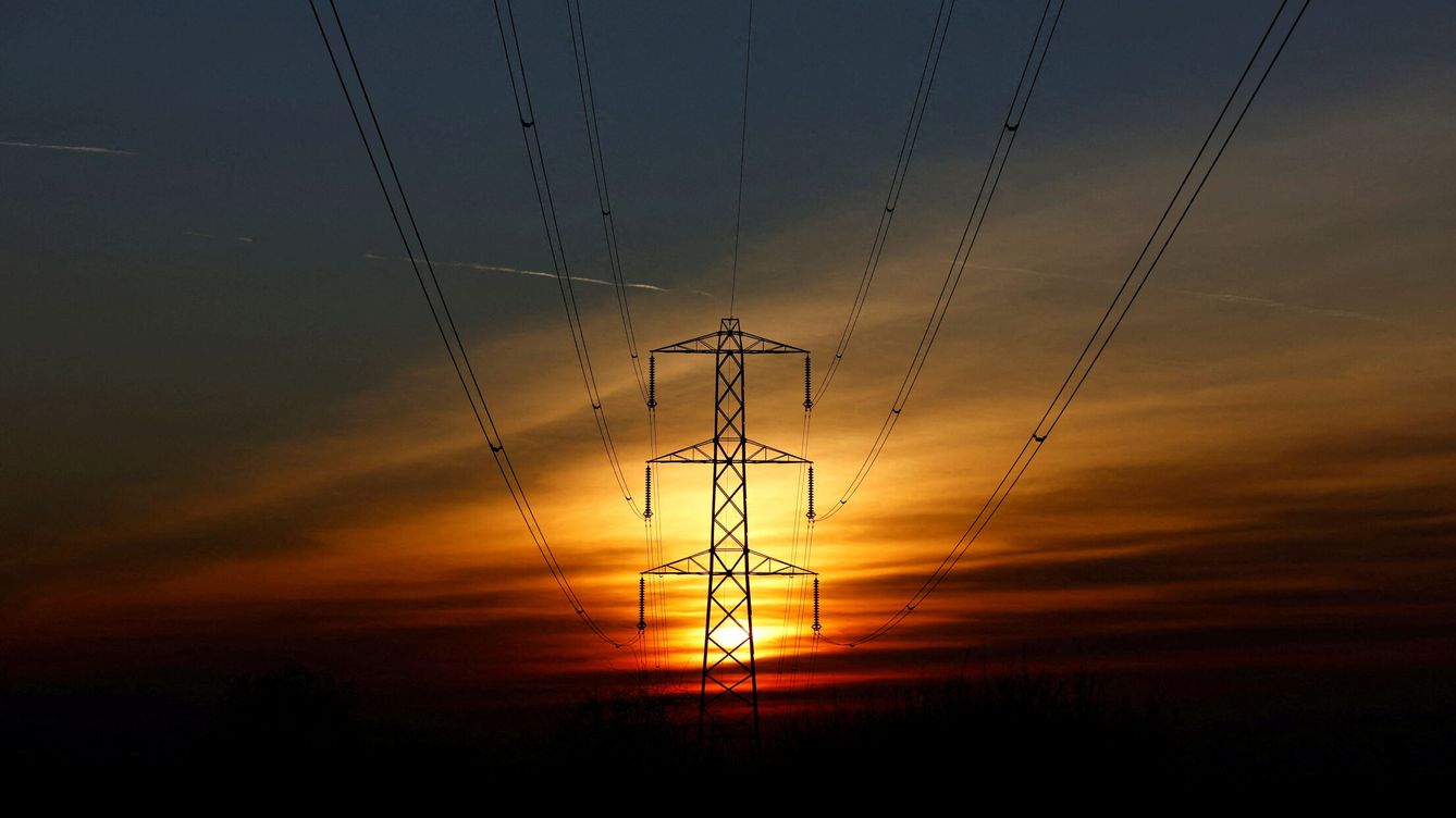 Foto: El sol se pone tras un pilón de electricidad en Petersfield, Inglaterra. (Reuters/Toby Melville)