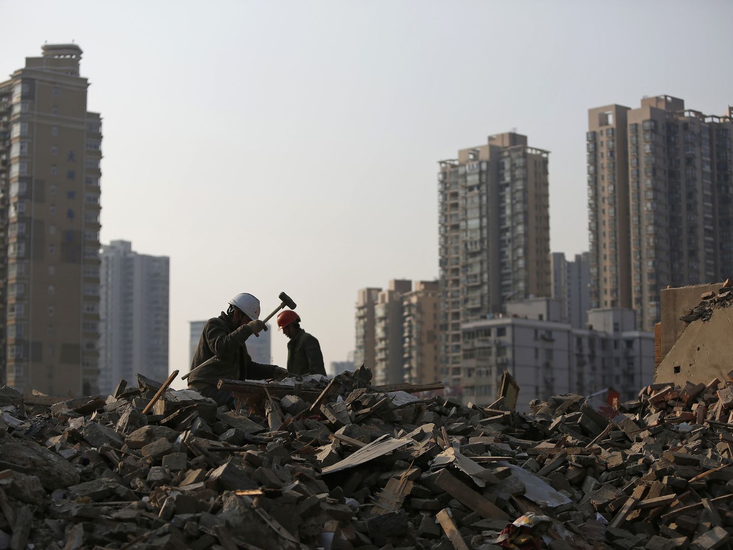 Obreros derriban edificios viejos en el centro de Shanghái (Reuters). 