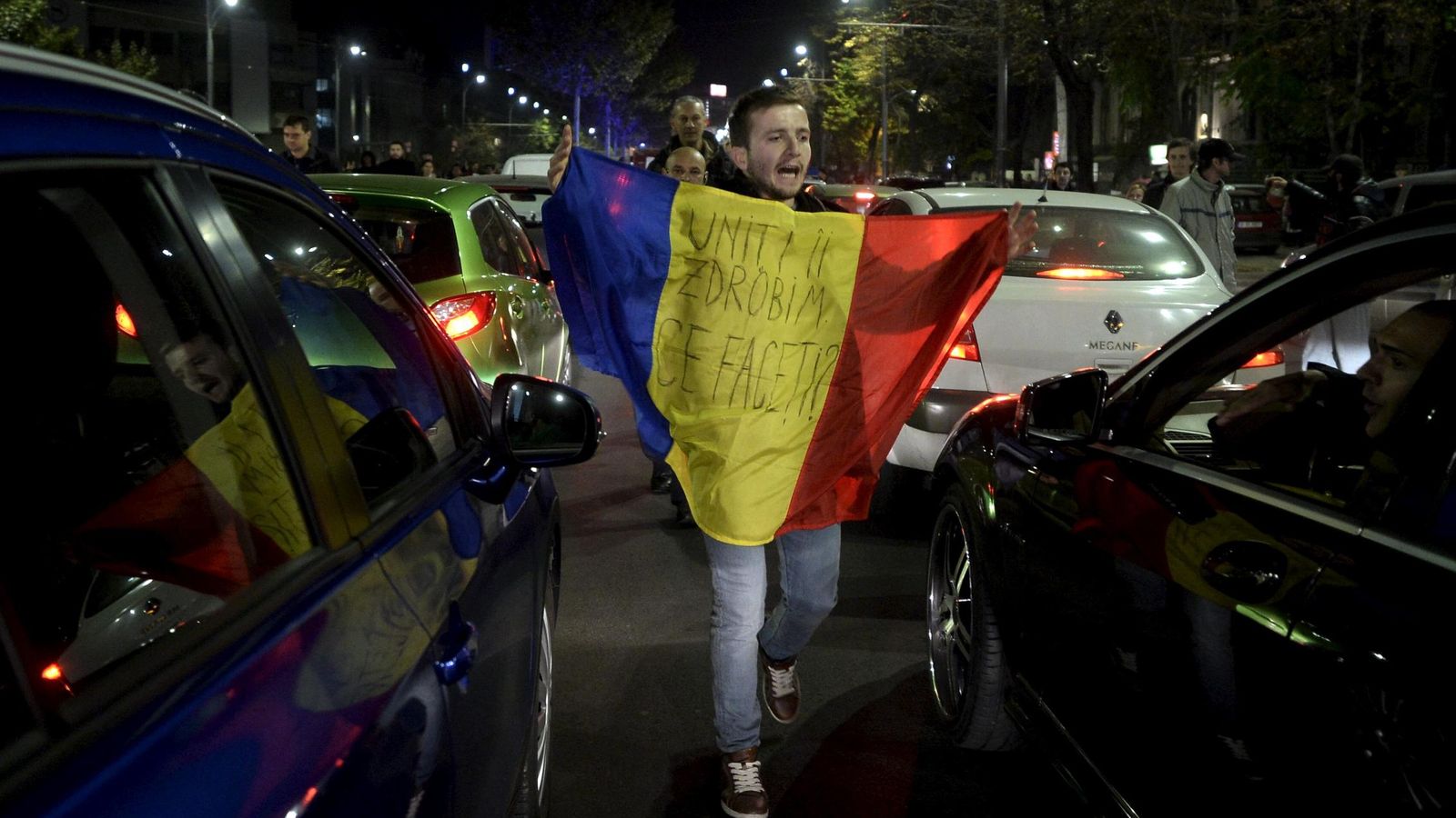 Foto: Un hombre protesta entre coches durante una protesta antigubernamental tras la tragedia del Club Colectiv, en Bucarest, el 3 de noviembre de 2015 (Reuters)