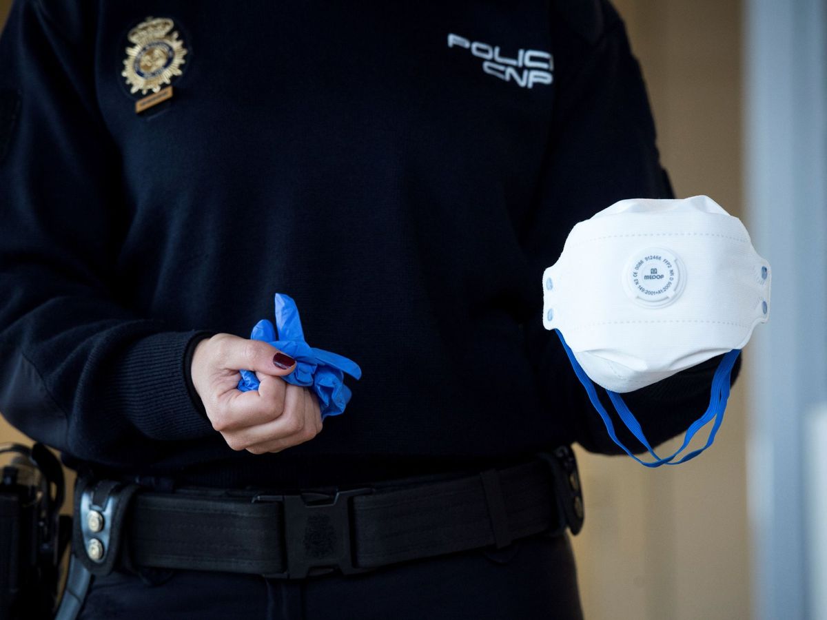 Foto: Un policía con una mascarilla y unos guantes. (EFE)