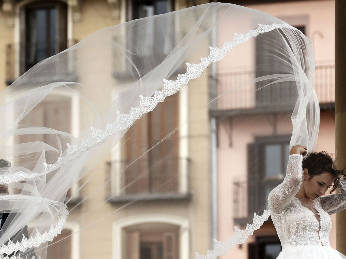 Foto: Las fuertes rachas de viento levantan el velo de una novia en el quiosco de la plaza del Castillo en Pamplona. (EFE/Jesús Diges)
