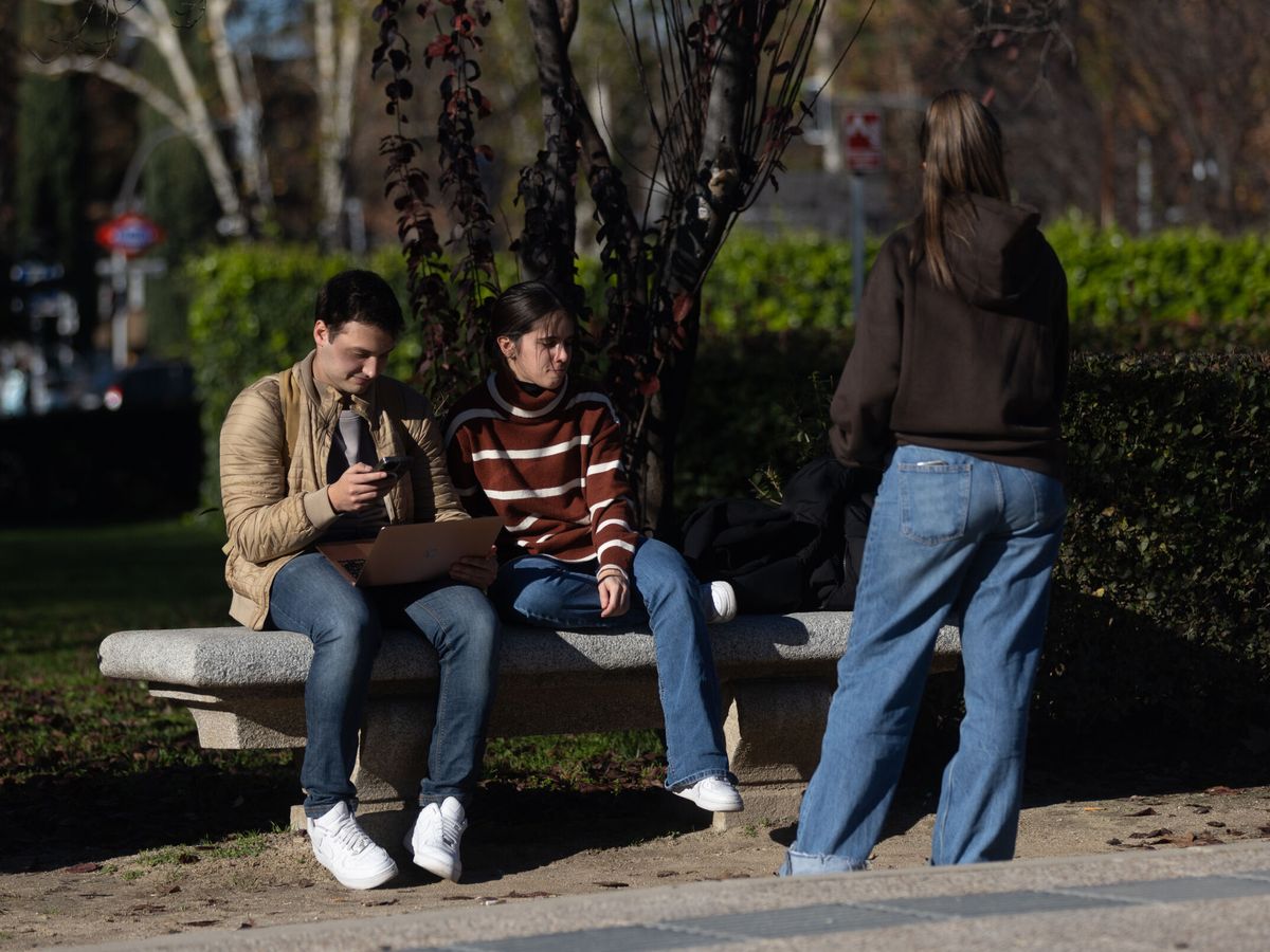 Foto: Varios jóvenes sentados en un banco en Madrid. (Europa Press/Eduardo Parra)
