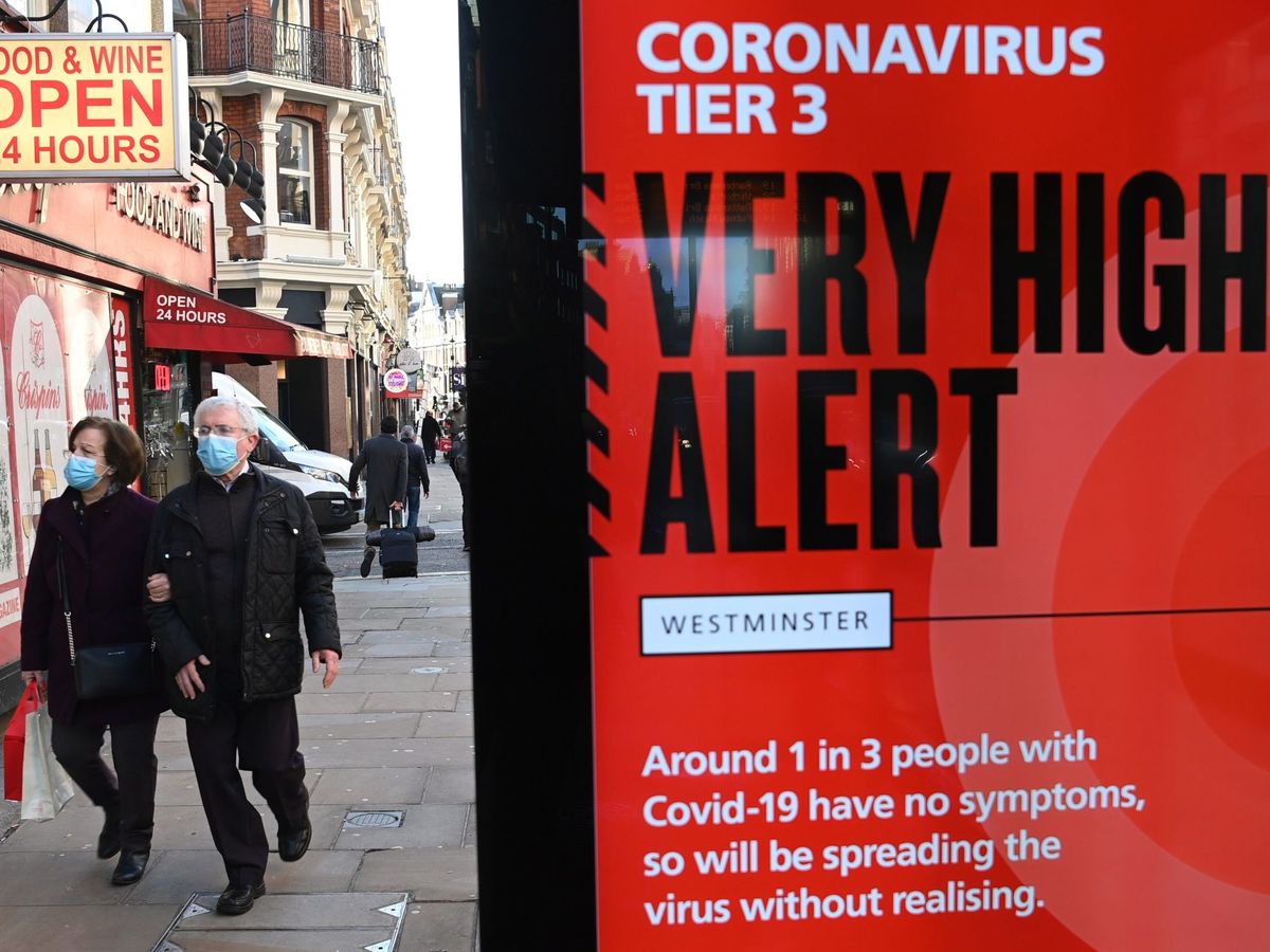 Foto: Viandantes pasan junto a un anuncio del Gobierno británico sobre el coronavirus. (EFE)