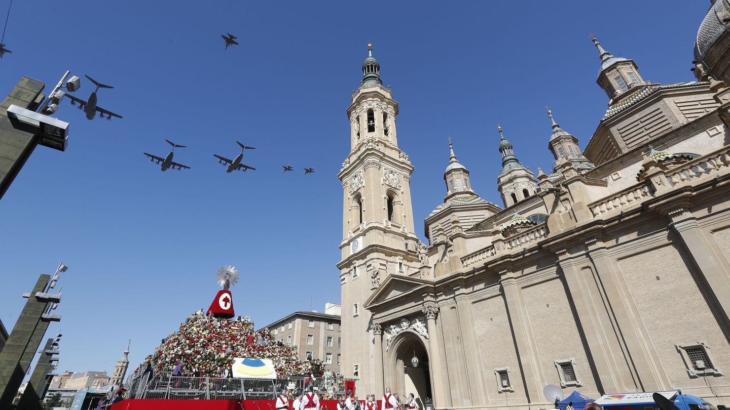 Varios aviones A-400 y F- 18 sobrevuelan la imagen de la Virgen del Pilar en una estructura levantada en el centro de la plaza de Zaragoza que lleva su nombre. (EFE/Javier Belver) 