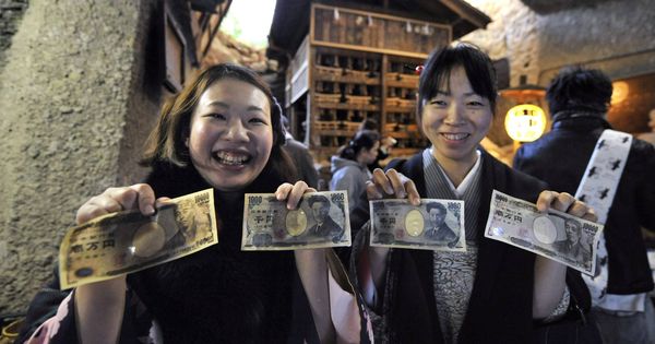 Foto: Dos jóvenes japonesas 'purifican' sus billetes con agua sagrada para atraer la suerte. (EFE)