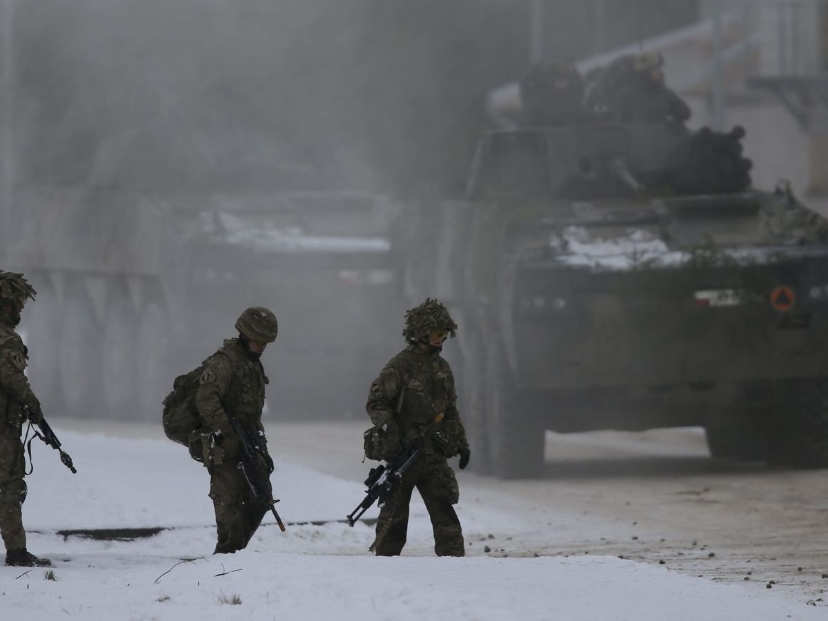 Foto: Unos soldados británicos pasan al lado de unos tanques polacos durante un ejercicio de defensa. (EFE/Olivier Hoslet)