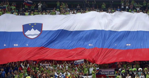 Foto: Aficionados de Eslovenia muestran su bandera durante un partido de baloncesto. (EFE)