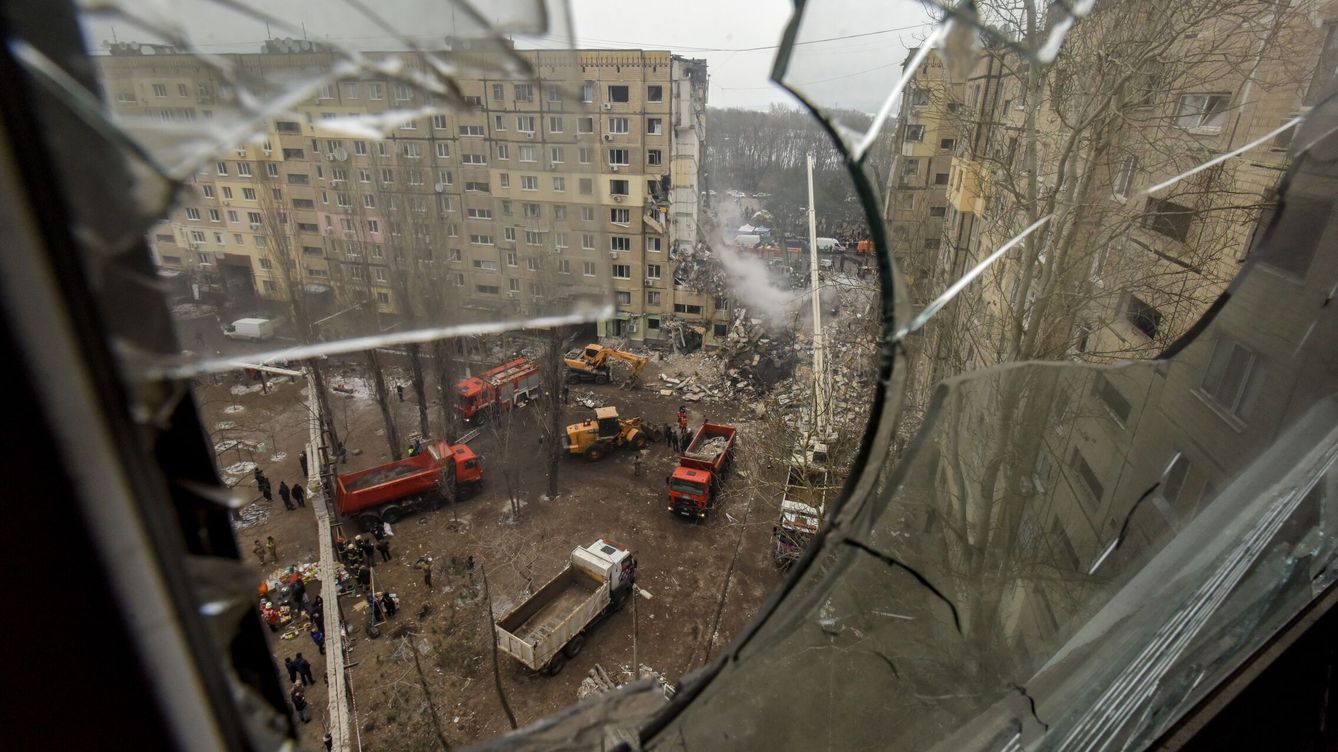 Foto: Vista tomada a través del cristal roto de una ventana que da al solar de un edificio residencial dañado mientras continúan las labores de rescate, en Dnipro. (EFE/Oleg Pertasyuk)