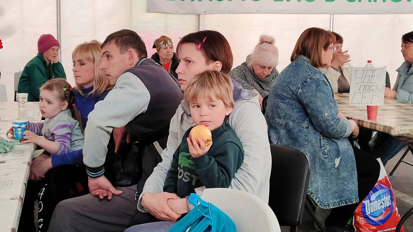 Un niños come una manzana en el centro de evacuados de Zaporiyia. (KAP)