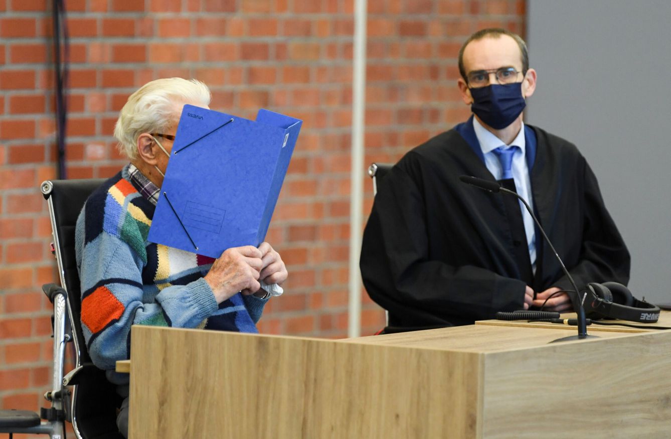 Schütz, con una carpeta cubriéndose el rostro, durante la primera vista de su juicio. (Reuters)