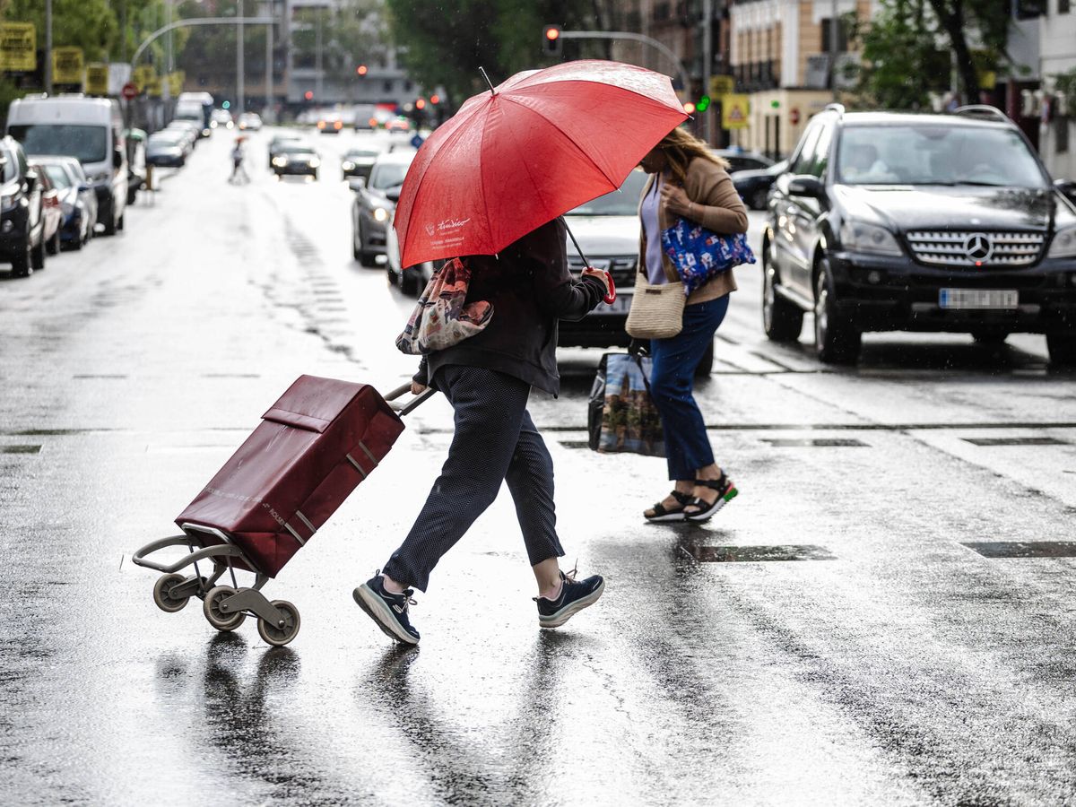 Foto: Dos personas caminan bajo la lluvia en Madrid. (Europa Press/Carlos Luján)