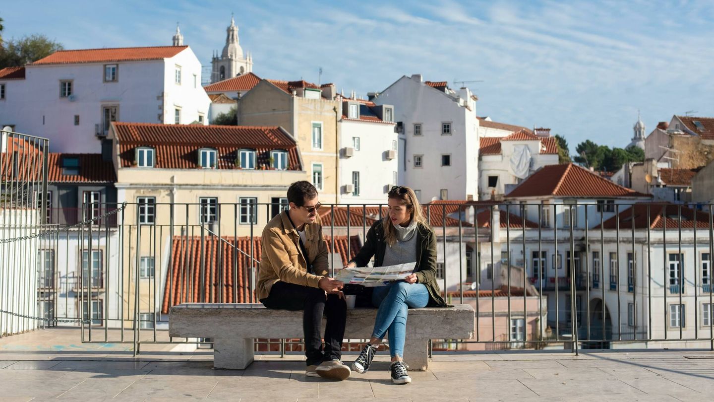 Una pareja de turistas consulta un mapa en papel. (Pexels)