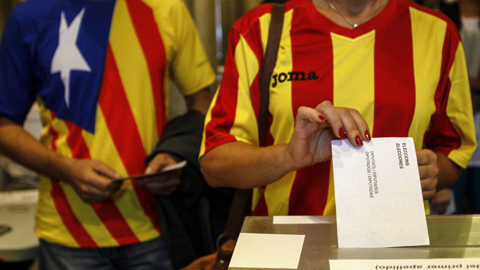 Foto: Una ciudadana deposita su voto en una mesa de en un colegio electoral de Barcelona. (Efe)