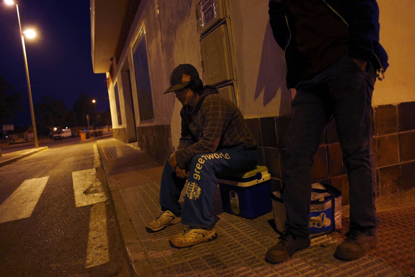 Un jornalero espera de madrugada a ser recogido para ir a los campos en Cartagena. (Reuters)
