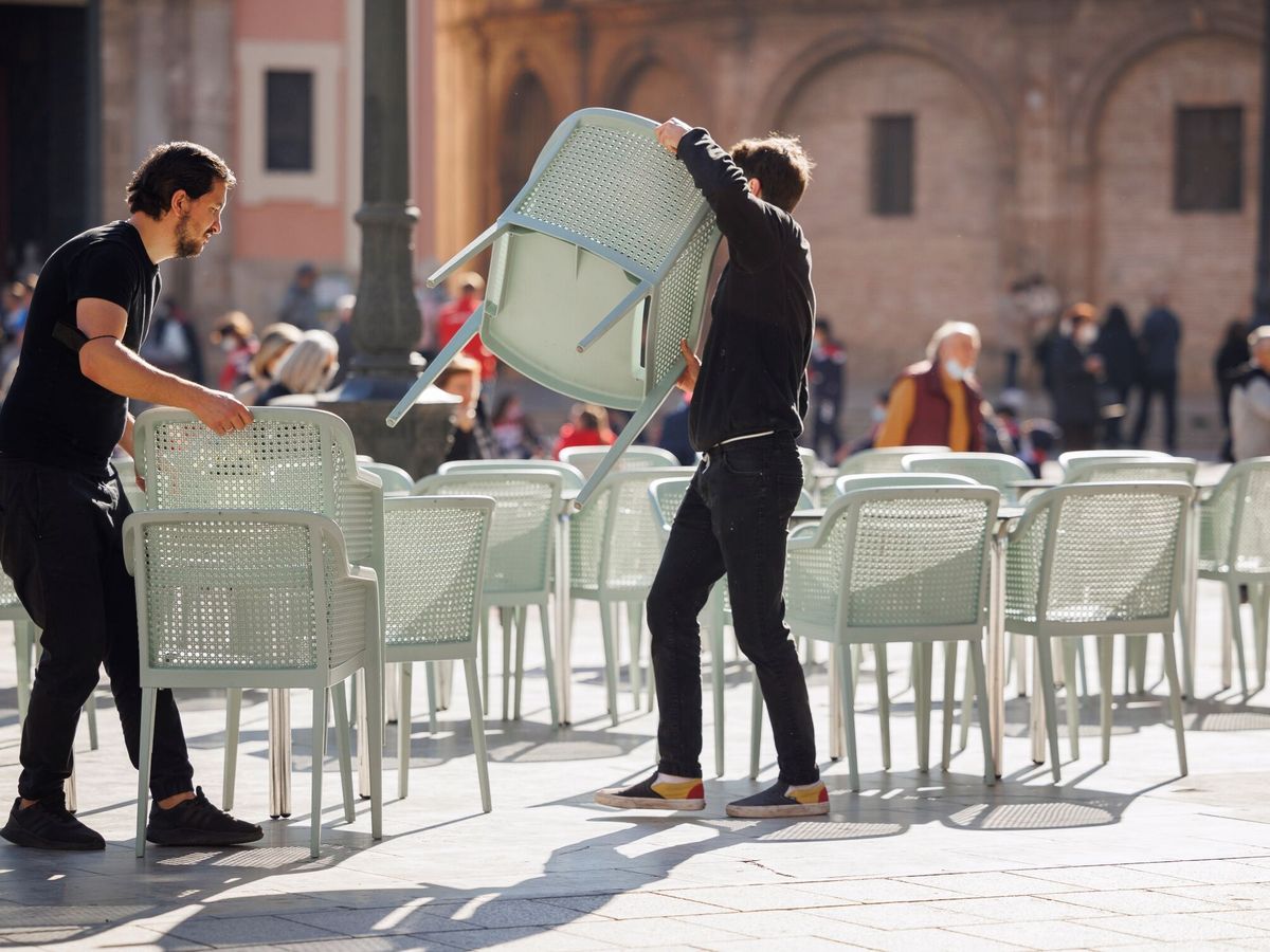 Foto: Dos camareros despliegan las mesas de una terraza. (EFE/Biel Aliño)