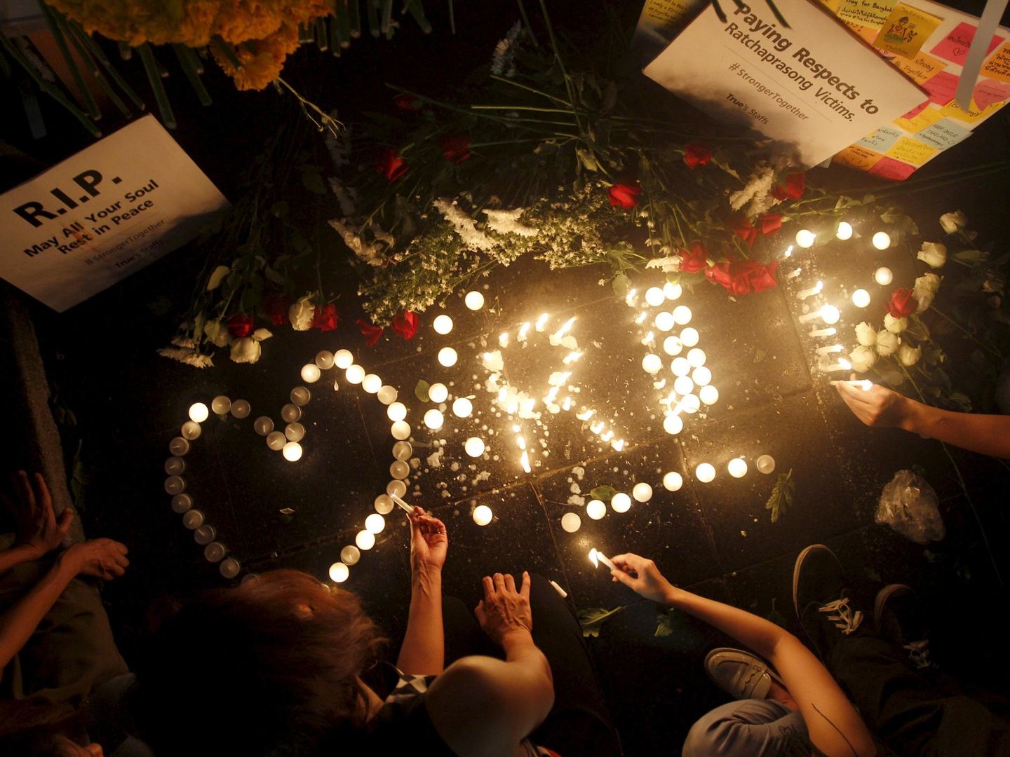 Un grupo de personas coloca velas en Erawan Shrine, lugar del atentado del lunes en el centro de Bangkok (Reuters).
