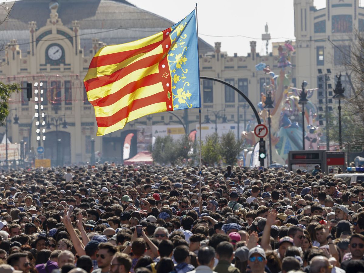Foto: La senyera valenciana ondea entre la multitud que asiste a la Mascletà. (EFE/Ana Escobar)