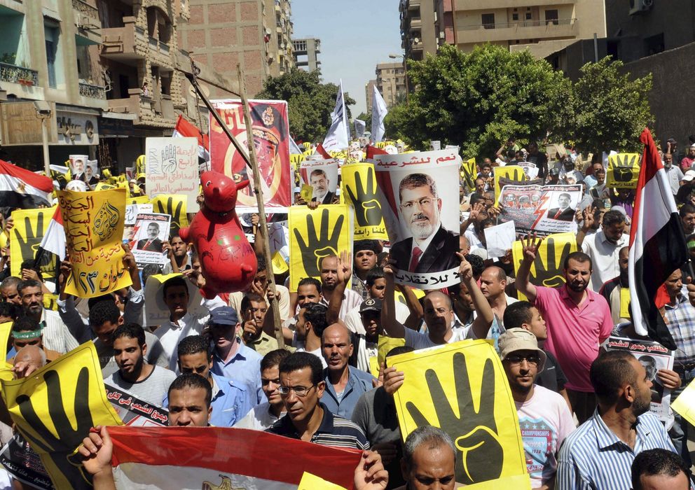 Foto: Seguidores de Mursi hacen en número cuatro con los dedos de la mano en referencia a la mezquita de Rabaa al Adauiy. (Efe)