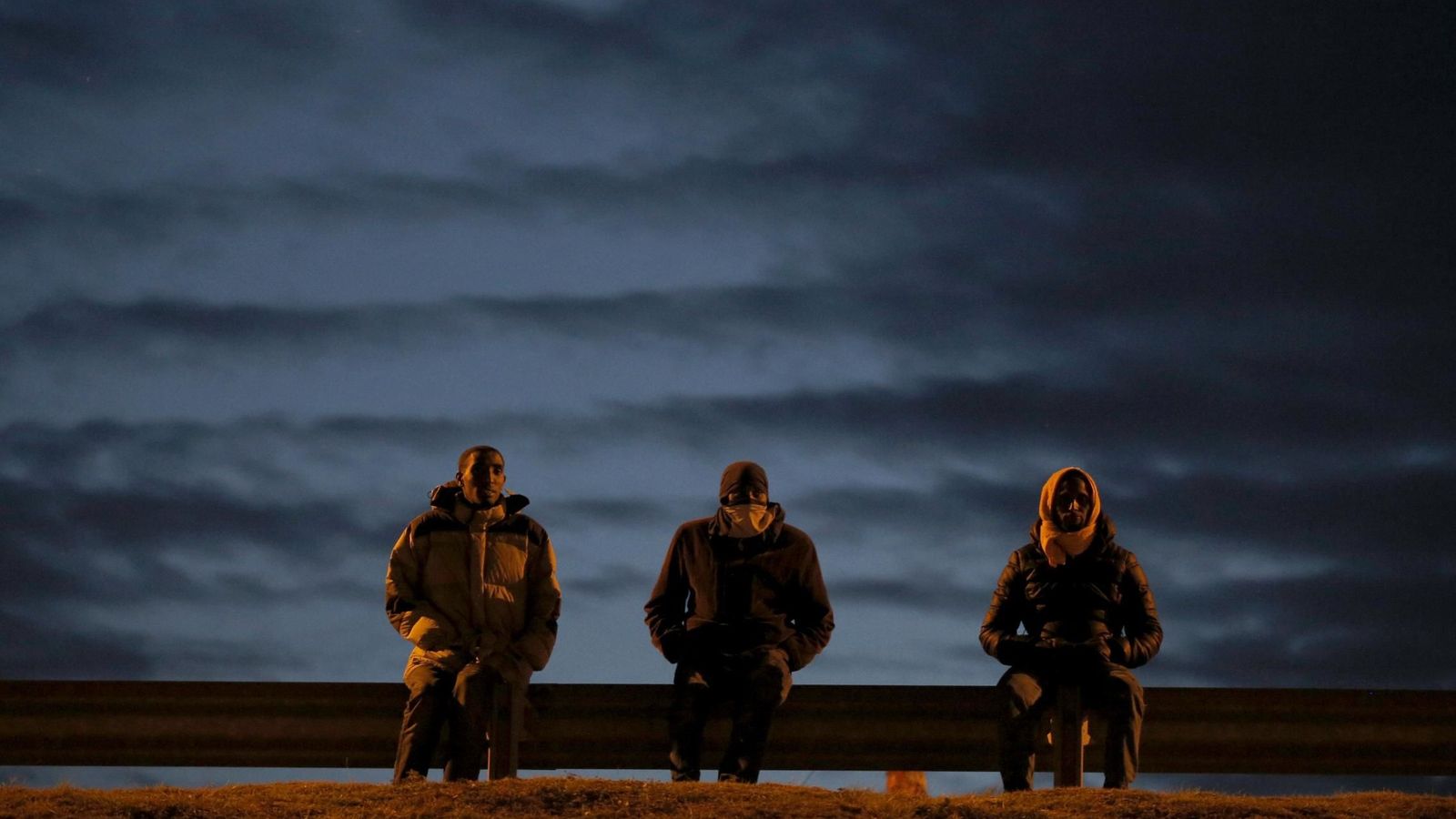 Foto: Migrantes se sientan junto a la carretera en Calais, cerca del Eurotúnel, el 4 de agosto de 2015 (Reuters).